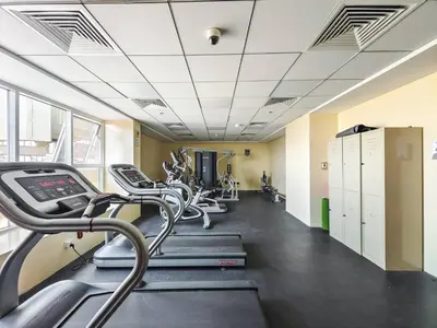 a gym with treadmills and elliptical machines at Special Rate - Luxurious Studio - Golf View in Dubai