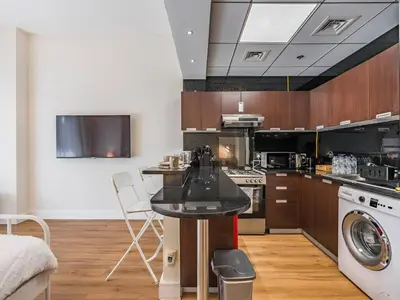 a kitchen with a table and a washer and dryer at Special Rate - Luxurious Studio - Golf View in Dubai