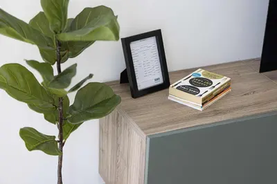 a table with a book and a clock and a plant at Stylish 1-Bedroom Apartment with Premium Amenities in Dubai