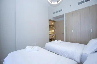 two beds in a hotel room with white sheets at Standard 2BHK located in Azizi riviera 46 in Dubai