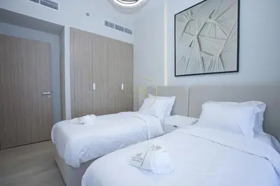two beds in a hotel room with white sheets at Standard 2BHK located in Azizi riviera 46 in Dubai