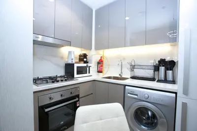 a kitchen with a washing machine and a microwave at Standard 2BHK located in Azizi riviera 46 in Dubai