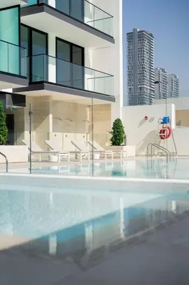 a building with a swimming pool in front of a building at Comfortable 1br Jvc Balcony Parking in Dubai