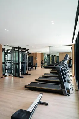 a gym with rows of treadmills and mirrors at Comfortable 1br Jvc Balcony Parking in Dubai