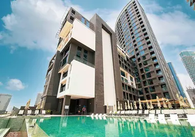 a building with a swimming pool in front of a building at Chic Studio with Top Amenities in Dubai