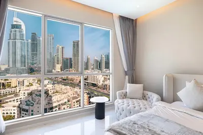 a bedroom with a large window with a city view at Downtown Sanctuary Iconic Burj Views & Luxury Living in Dubai