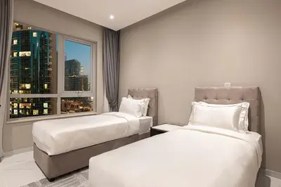 a hotel room with two beds and a window at Downtown Sanctuary Iconic Burj Views & Luxury Living in Dubai