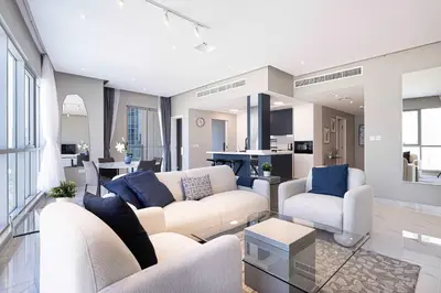 a living room with a white couch and blue pillows at Downtown Sanctuary Iconic Burj Views & Luxury Living in Dubai