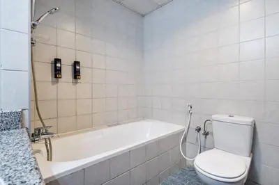 a bathroom with a tub and a toilet and a sink at 021 - Discovery Gardens (Building 18) in Dubai