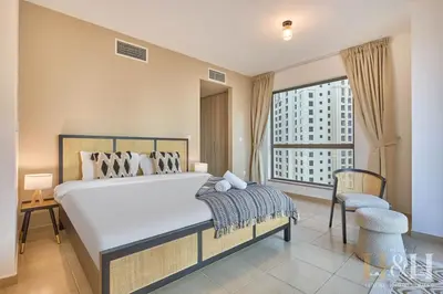 a bedroom with a large bed and a large window at Stunning views of Dubai Sea, Dubai Eye & JBRWalk in Dubai