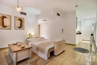 a bedroom with a large bed and a table at Stunning views of Dubai Sea, Dubai Eye & JBRWalk in Dubai