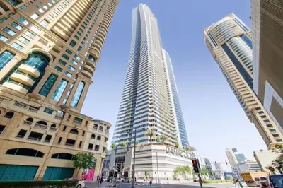 a tall building in the middle of two tall buildings at Ocean Heights - One Bed with City View of Marina in Dubai