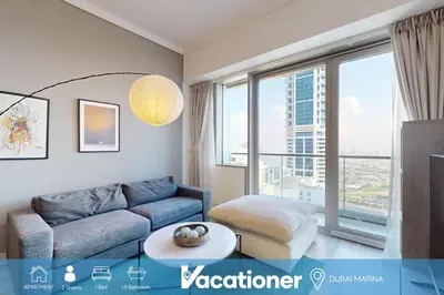 a living room with a couch and a large window at Ocean Heights - One Bed with City View of Marina in Dubai