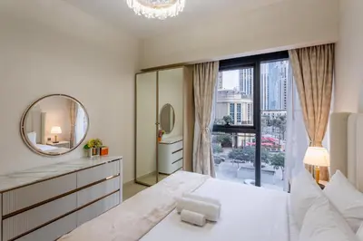 a white bedroom with a mirror and a large window at Act One Act Two - Exquisite One Bed in Downtown in Dubai