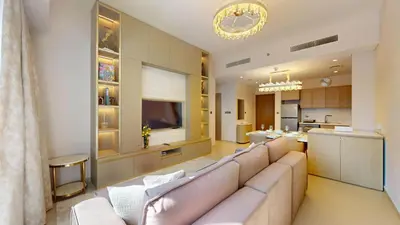 a living room with a large couch and a kitchen at Act One Act Two - Exquisite One Bed in Downtown in Dubai
