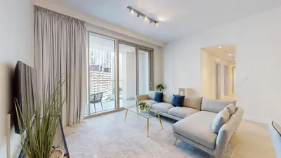 a living room with a couch and a large window at Forte Tower - Aesthetic Three Bedroom in Downtown in Dubai
