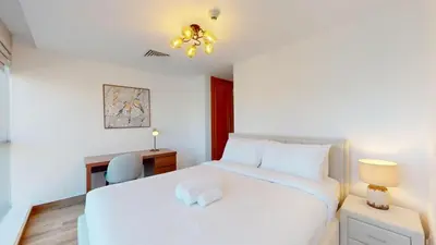 a bedroom with a white bed and a desk at Vacationer I Hidden Gem in Marina l 3 Bedroom I Yacht Views, Free Pool, Gym & Wi-Fi in Dubai