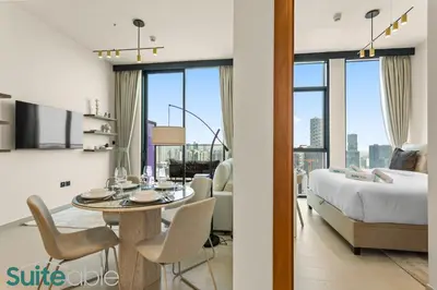 a bedroom with a bed and a dining room with a table at Perfect Blend of Comfort and Cozy 1 Bedroom in JVC in Dubai