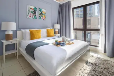a bedroom with a large white bed with yellow pillows at Frank Porter - Yansoon 5 in Dubai