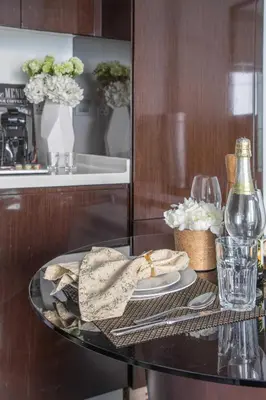 a glass table with a plate of food and a bottle of wine at Frank Porter - Damac Majestine in Dubai