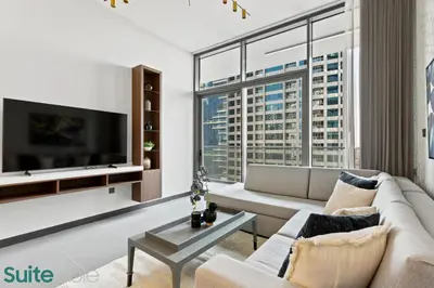 a living room with a couch and a tv at Elegant 1-Bedroom with Stunning Lake View in JLT in Dubai