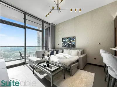 a bedroom with a bed and a couch and a table at Elegant 1-Bedroom with Stunning Lake View in JLT in Dubai