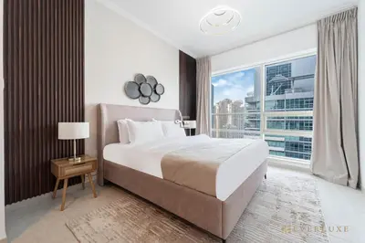 a bedroom with a large bed and a large window at Beautiful & Spacious 3 Bedroom Wmaids In Marina in Dubai
