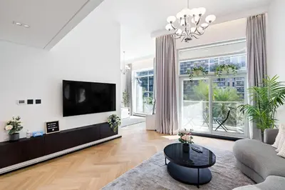 a living room with a tv and a couch at 1 BR Exquisite Urban Living in Downtown Dubai in Dubai