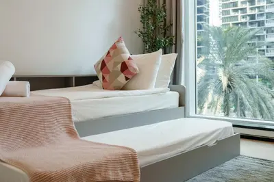 two beds in a room with a window at 1 BR Exquisite Urban Living in Downtown Dubai in Dubai