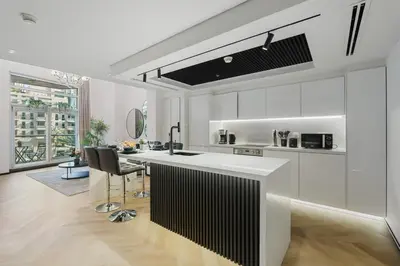 a white kitchen with a black and white counter at 1 BR Exquisite Urban Living in Downtown Dubai in Dubai