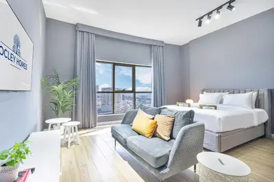 a hotel room with a bed and a couch at Stylish & Compact Home in the Heart of the JVC in Dubai