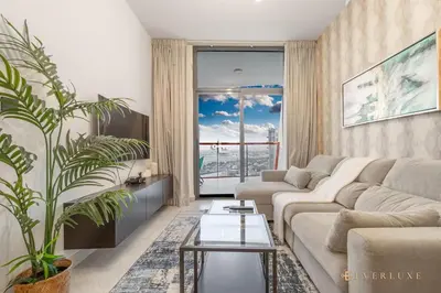 a living room with a couch and a large window at 1-bedroom Apartment In Binghatti Avenue in Dubai