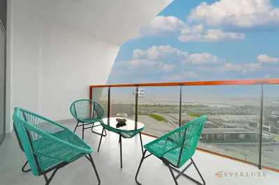 a balcony with two chairs and a table with a view at 1-bedroom Apartment In Binghatti Avenue in Dubai