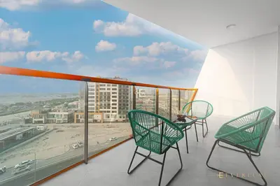 two chairs on a balcony with a view of a beach at 1-bedroom Apartment In Binghatti Avenue in Dubai