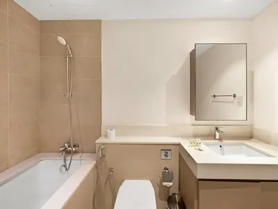 a bathroom with a tub and a toilet and a sink at Park View Stay at Creek Horizon in Dubai