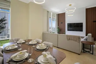 a dining room with a table with plates and wine glasses at 13 - Stylish Dorra Bay Family Apartment - Canal View & Pool Access in Dubai