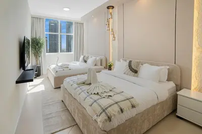a bedroom with a large bed and a couch at 13 - Stylish Dorra Bay Family Apartment - Canal View & Pool Access in Dubai