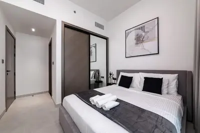 a bedroom with a large bed with two towels on it at Cozy 1BR apartment Binghatti Canal Business Bay in Dubai
