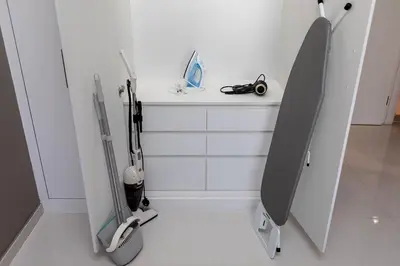 a white room with a white wall with two dental equipment at Modern 1BR apartment Artesia DAMAC Hills in Dubai