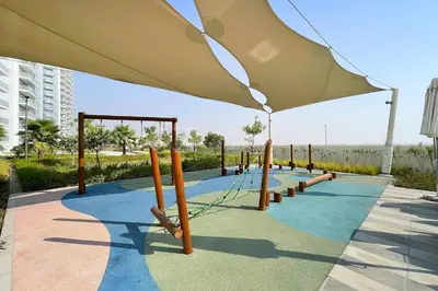 a playground with a large umbrella on a sidewalk at Modern 1BR apartment Artesia DAMAC Hills in Dubai