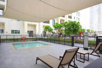 a patio with chairs and a swimming pool in a building at Breeze haven residences- 2BHK brand new furnished apartment in Dubai