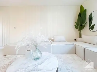 a white living room with a vase on a table at Your Perfect Meydan Getaway 1B Polo Residence C3 in Dubai