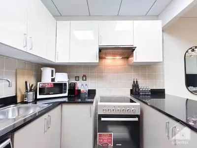 a kitchen with white cabinets and a sink at Your Perfect Meydan Getaway 1B Polo Residence C3 in Dubai