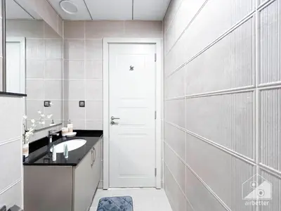 a bathroom with a sink and a white door at Your Perfect Meydan Getaway 1B Polo Residence C3 in Dubai