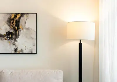 a lamp in a room next to a couch at Burj Royale Dubai Downtown in Dubai