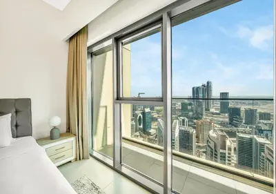 a bedroom with a large window with a city view at Burj Royale Dubai Downtown in Dubai