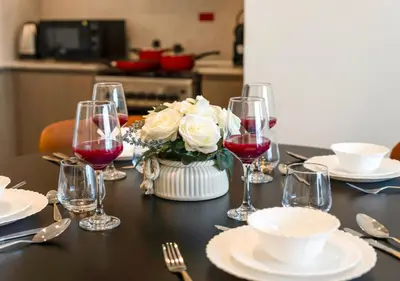 a table with wine glasses and a vase of flowers at Burj Royale Dubai Downtown in Dubai