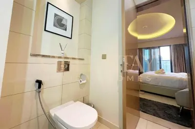 a bathroom with a toilet and a bed in a room at Prime 1BR Location Minutes to Burj Dubai Mall by Vibel in Dubai