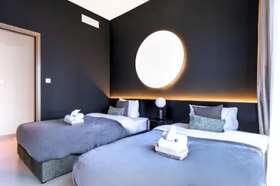 two beds in a room with a round window at Luxury At The Top- Iconic Burj Views-Dubai Mall Access 2BR by Maxx Value Homes in Dubai