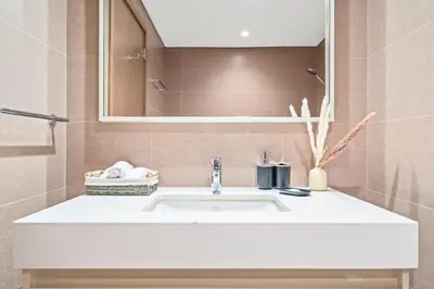 a bathroom with a white sink and a mirror at Luxury At The Top- Iconic Burj Views-Dubai Mall Access 2BR by Maxx Value Homes in Dubai